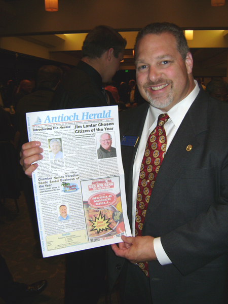 Jeff Warrenburg holds front cover the Herald Paradise Skate Named Antiochs 2010 Small Business of the Year