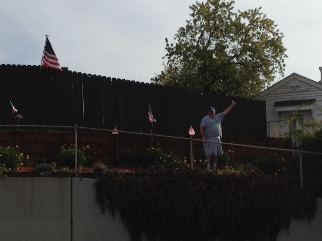 Ken Gray places flags on his and his wife (Antioch School Board Trustee) Diane's property above A Street for Veterans Day.