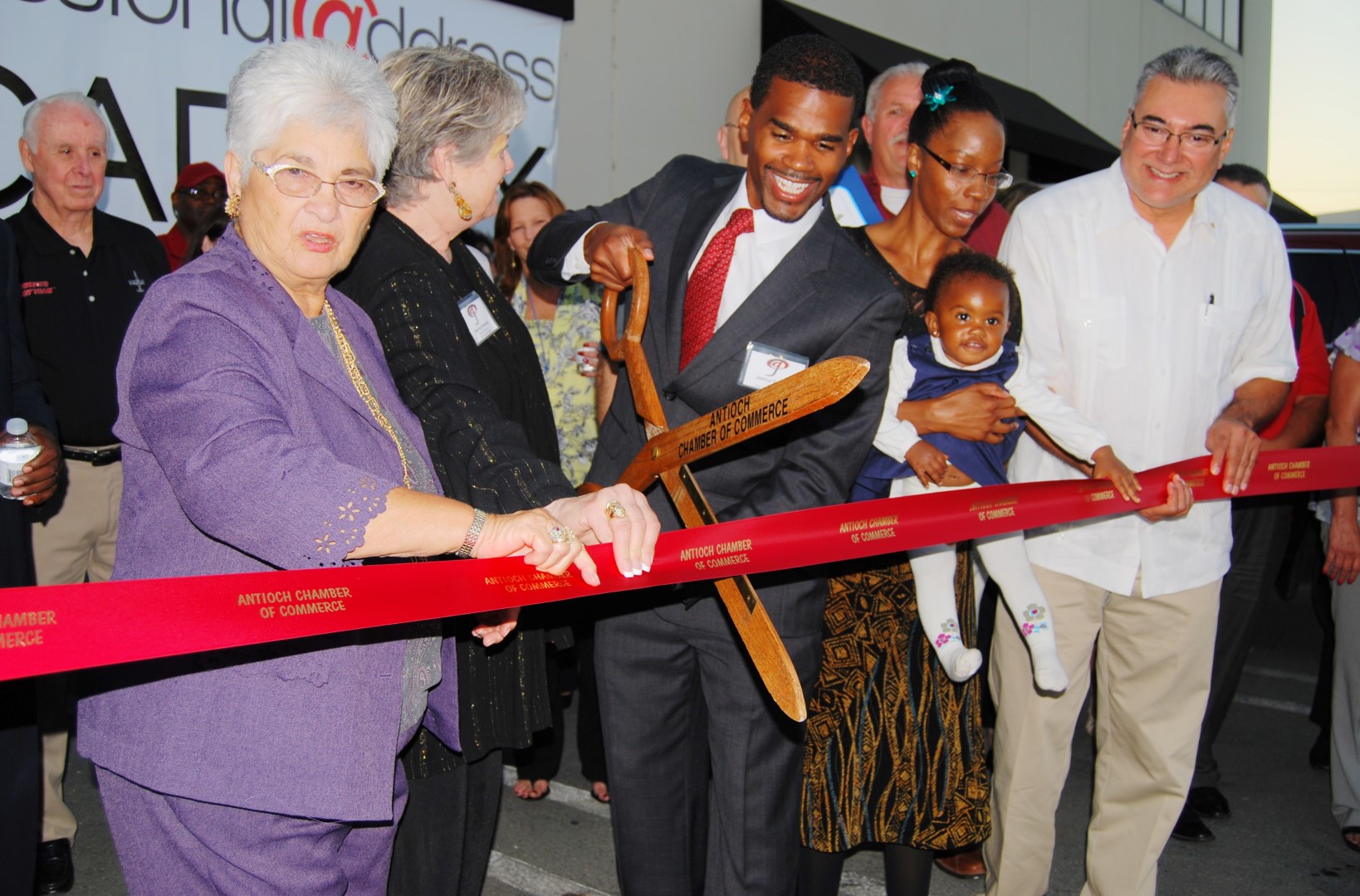 Professional Address CEO and Founder Joshua Samuel cuts the ribbon as Antioch Mayor Pro Tem Mary Rocha, left, Josh's wife and baby, and Councilman Tony Tiscareno assist.