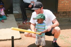Michael McCarthy teaches batting to an orphan during a 2014 trip to South Africa.
