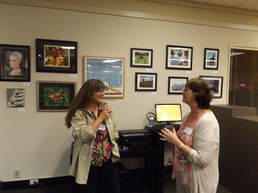 Bernice Lucerno and Lori Cook, whose artwork is on display, talk during the Umpqua Art Exhibit reception on Wednesday, February 4, 2015.