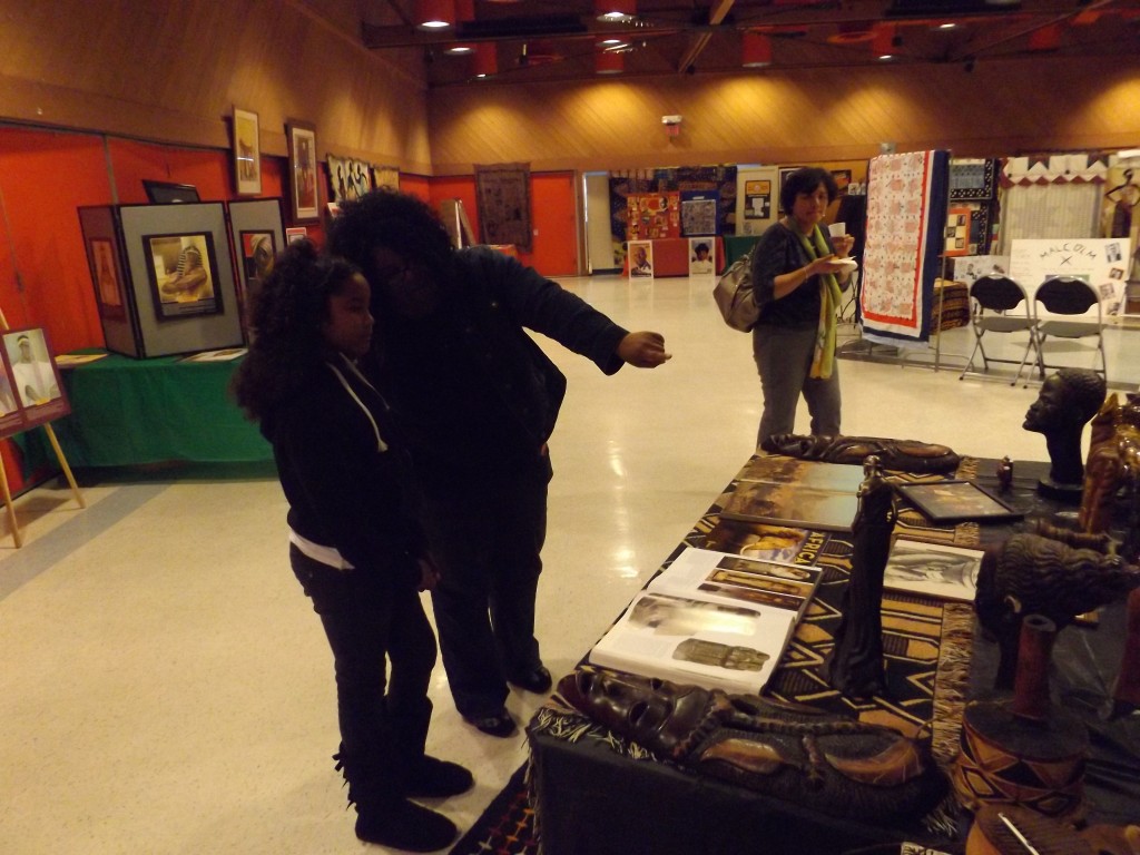Janet Sams explains the display to her friend's daughter, Elise Sanders, at the Black History Month Exhibit in Antioch.