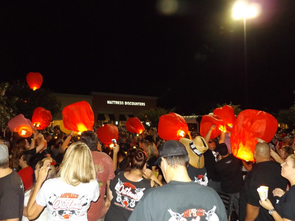 Attendees light the lanterns at Lumpy's vigil, Friday night.