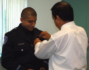 Rishi Negi gets his badged pinned on his uniform by his father Rajan.