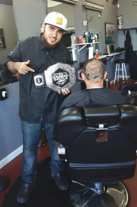 Derek, in Ajja's, with his belt and a new design on a client's head.