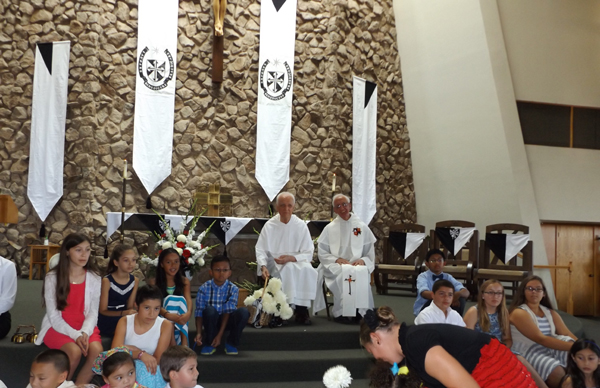 A procession of children brought flowers to Father Vicente, center left, at the beginning of the multi-cultural mass in his honor, at Most Holy Rosary Catholic Church in Antioch, on Saturday, August 29, 2015.