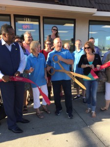 Owner Paul Spangenberg cuts the ribbon, while his wife Georgia, Mayor Wade Harper (left) on others watch.