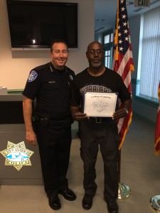 Chief Cantando presents Citizens Academy graduate Lorenzo Macon with his diploma and gifts.