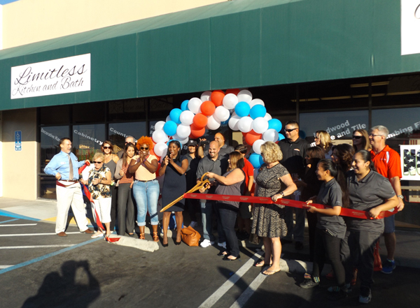 Business and community leaders cheer as owners Lou and Vanessa Hellmann, with scissors, cut the ribbon to officially open their new business Limitless Kitchen & Bath in Antioch, Thursday afternoon.
