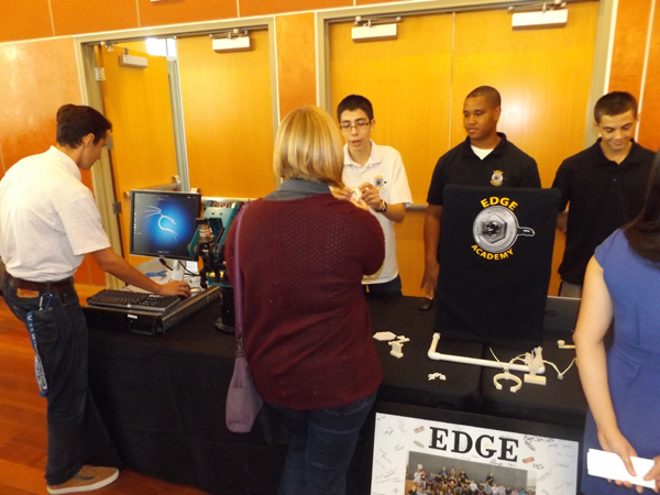 Antioch High School juniors Kevin Roldan, Darian Quinn and Robert Gochenouer speak with Amanda Hauf, a chemical engineer with Dow Chemical in Pittsburg, while junior Hudson Preece works the laptop at the EDGE Academy display.