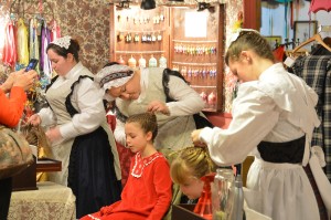 Proper young ladies have their hair beautifully braided at the Great Dickens Christmas Fair.