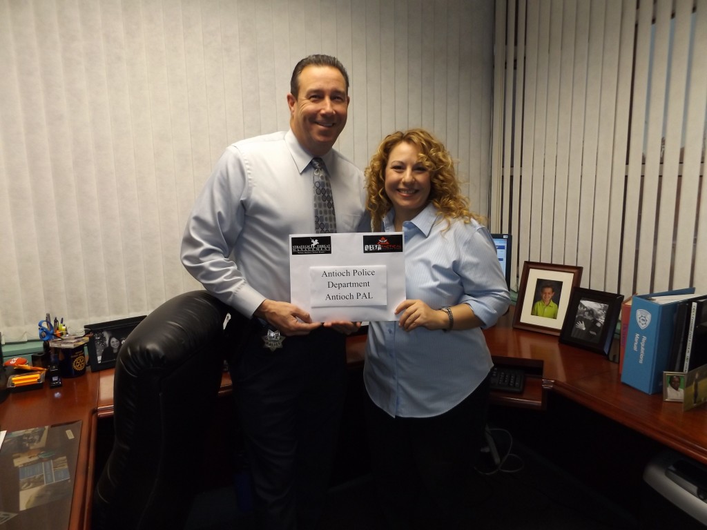 Antioch Police Chief Allan Cantando presented with an envelope full of checks and cash for the Antioch Police Activities League from Amy Dopart of Strategic Threat Management on Thursday, January 14, 2016.