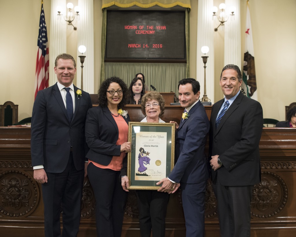 2016 AD 11 Woman of the Year Gloria Martin holds her resolution on the floor of the Assembly, accompanied by Assemblymembers, from left,  Chad Mayes (Minority Leader), Cristina Garcia (Women’s Caucus Vice Chair), Speaker Anthony Rendon and Jim Frazier.