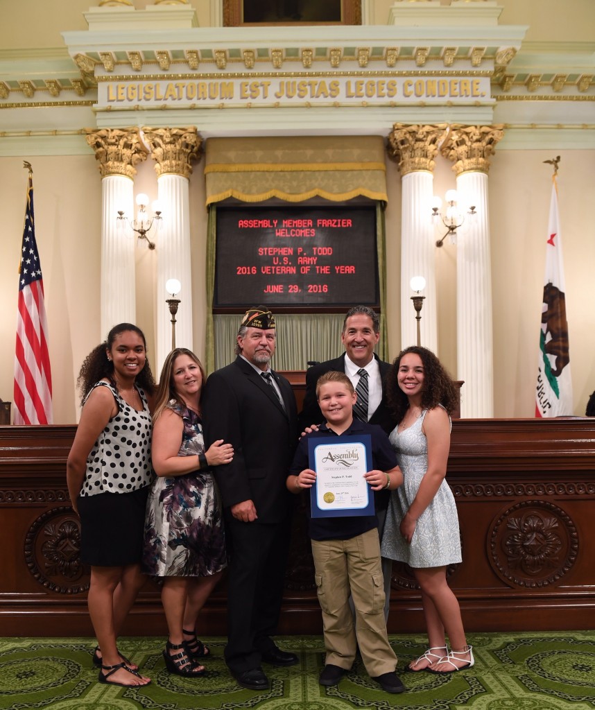 Stephen Todd and his family with Assemblyman Frazier on the floor of the State Assembly.