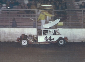 Jerry Hetrick #44a takes a checkered flag in his track record holding Sportsman in 1975.  Photo From The Jerry Hetrick Collection.