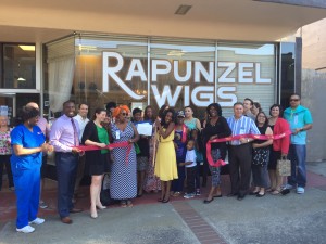 Rapunzel Wigs owner Angie Bashir-Hicks celebrates with friends, family and community leaders as she cuts the ribbon to officially open her business on May 25, 2016