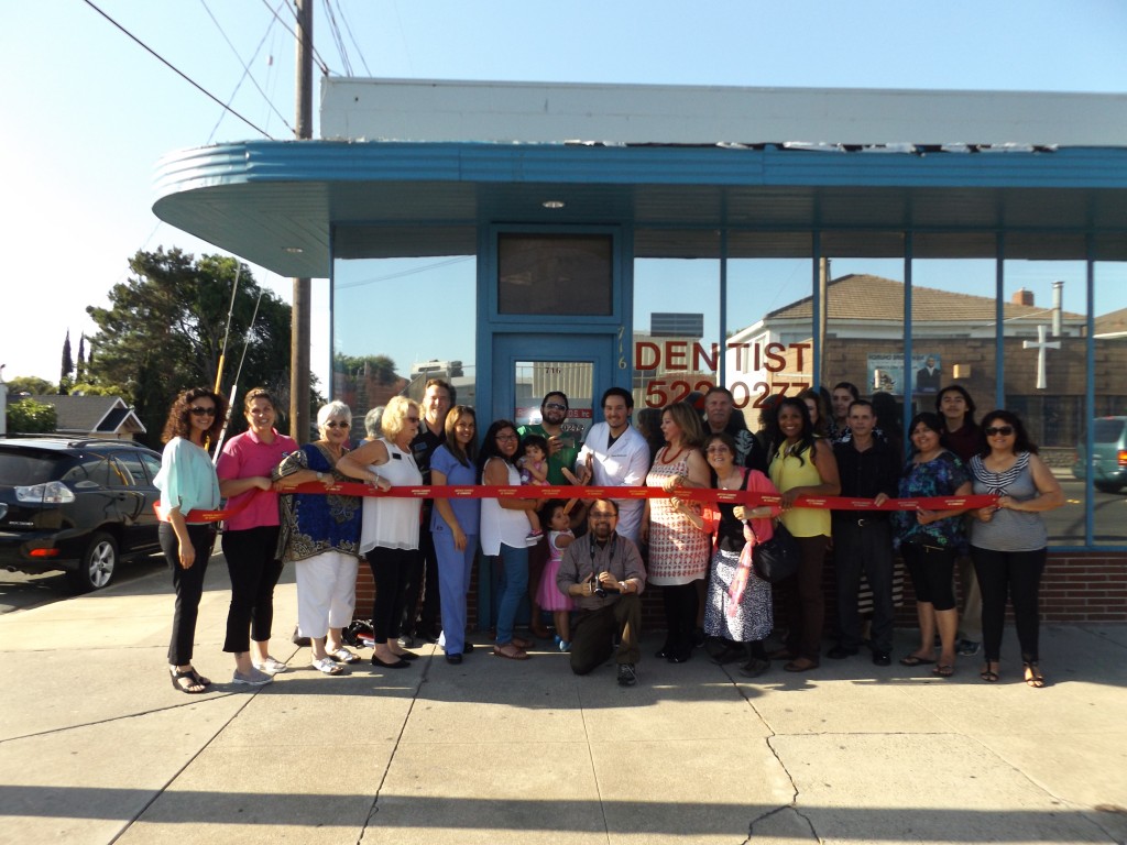 Dr. Rodrigo Martell, with scissors, prepares to cut the ribbon at his new office, with members of his family, as well as Antioch council members, and Chamber of Commerce leaders and members on Wednesday, May 18.