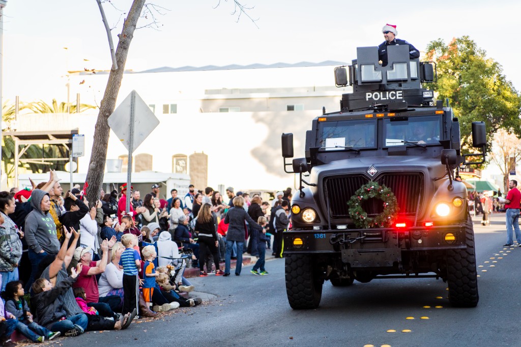 A No Shave November bearded Antioch Police Chief Allan Cantando tosses out candy from the department's assault vehicle. Photo above by Michael Pohl.