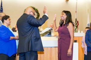 Re-elected Councilwoman Monica Wilson is given her oath of office by her brother Terrance, while their mother and Uncle 