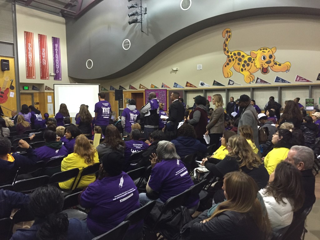 Supporters of the Rocketship charter school in Antioch line up to speak at Wednesday night's special school board meeting, as other supporters in purple shirts and opponents in yellow shirts listen.