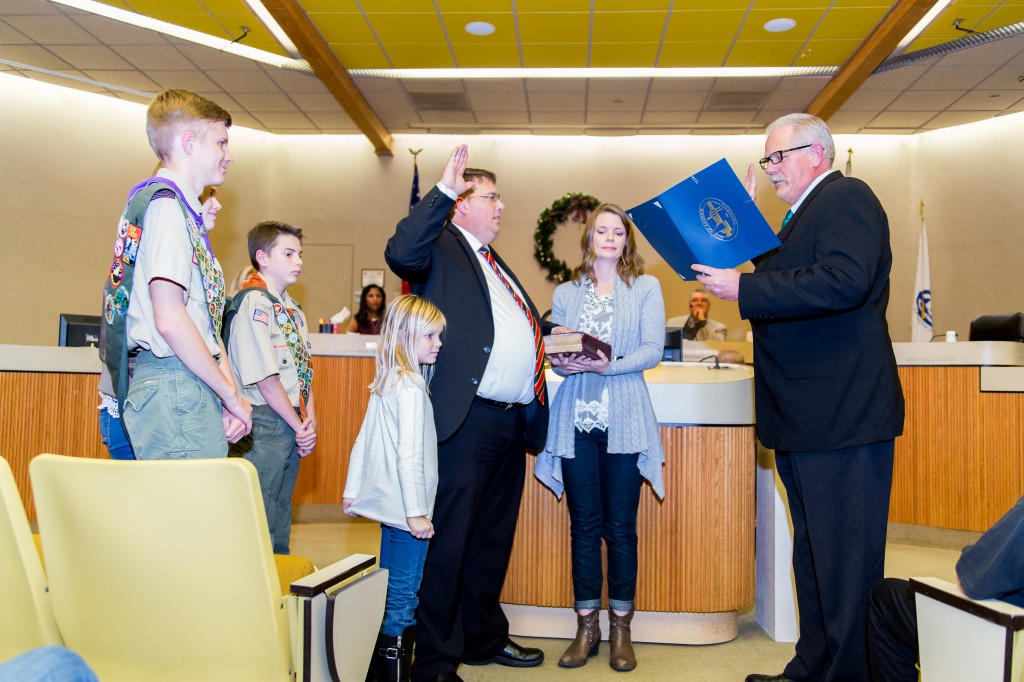 Dr. Sean Wright takes the oath of office administered by his uncle, Oakley Mayor Kevin Romick, with Wright's wife Lani holding the Bible, and their children by his side, during ceremonies, Thursday night. Photo by Michael Pohl.